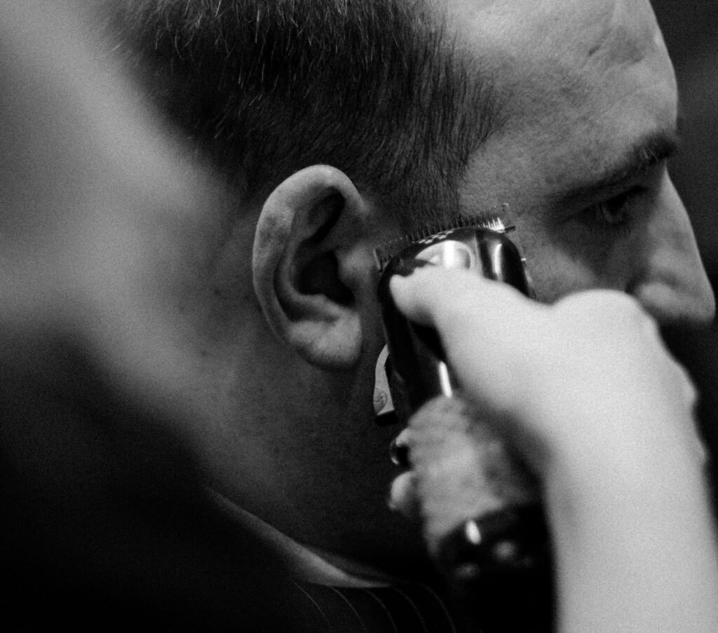 A detailed black and white image of a haircut being done with a clipper.