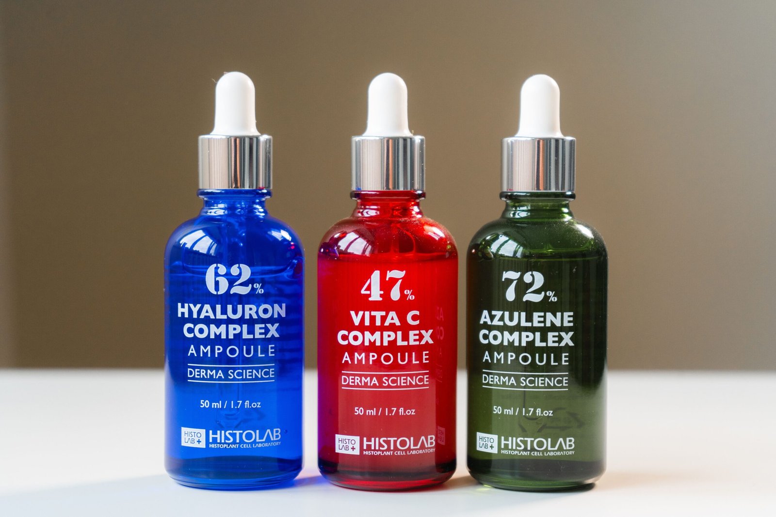 Three vibrant ampoule bottles for skincare solutions, ideal for cosmetic product showcases.